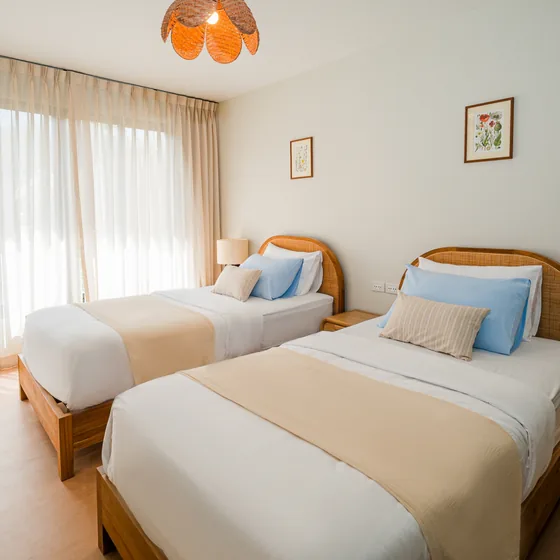 Twin bedroom in the family apartment with arched rattan headboards