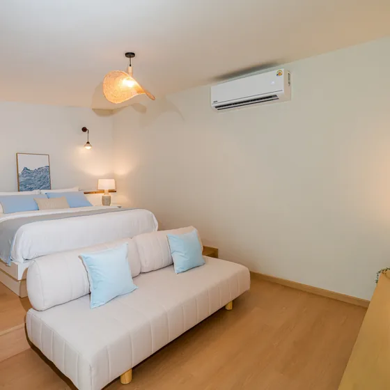 The Deluxe room, king bed with a long sofa at the foot