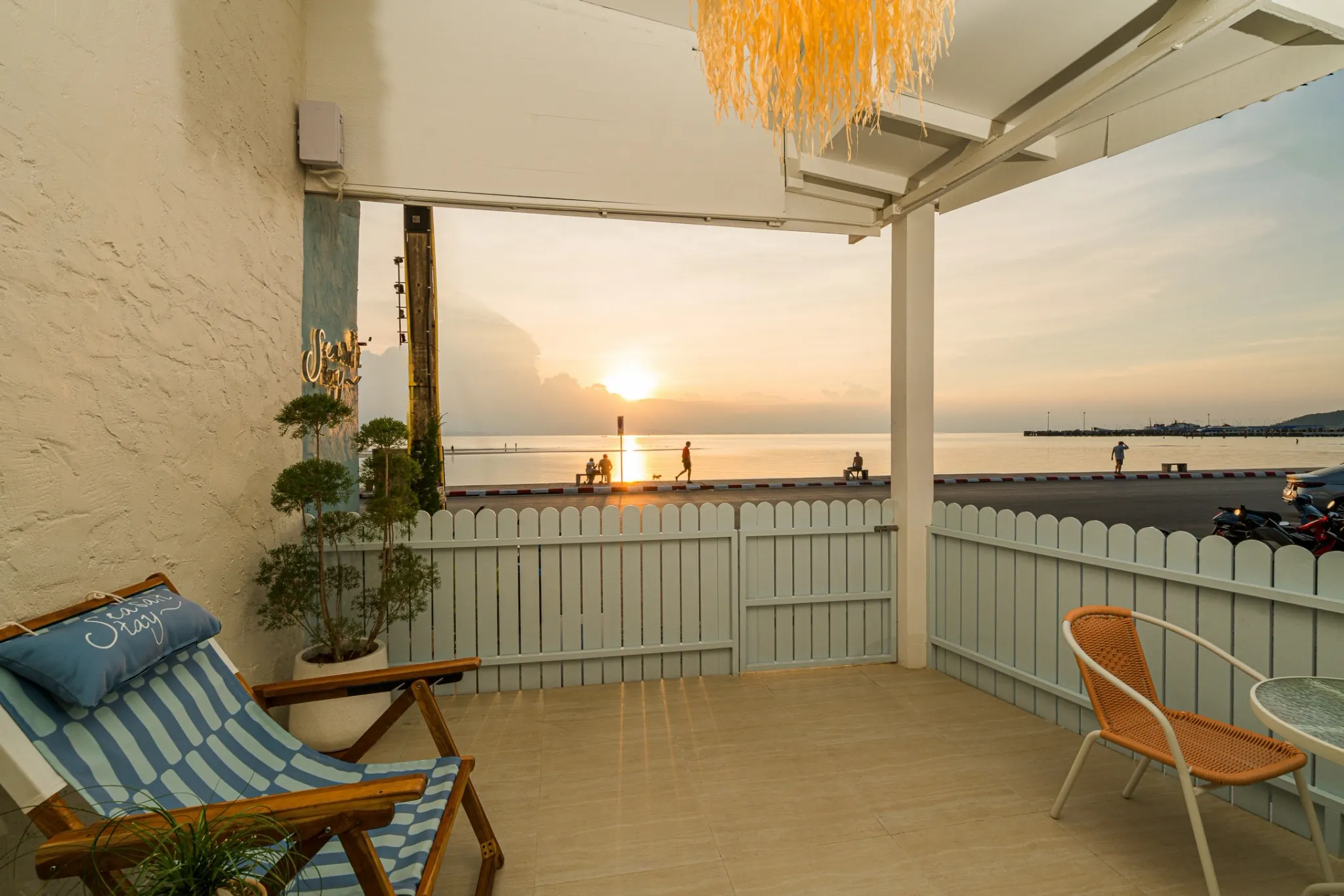 The terrace at sunset, looking across the coastal road to the sea